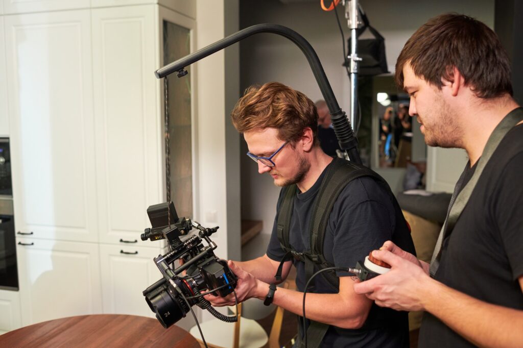 Two videographers or cameraman and his assistant preparing for shooting